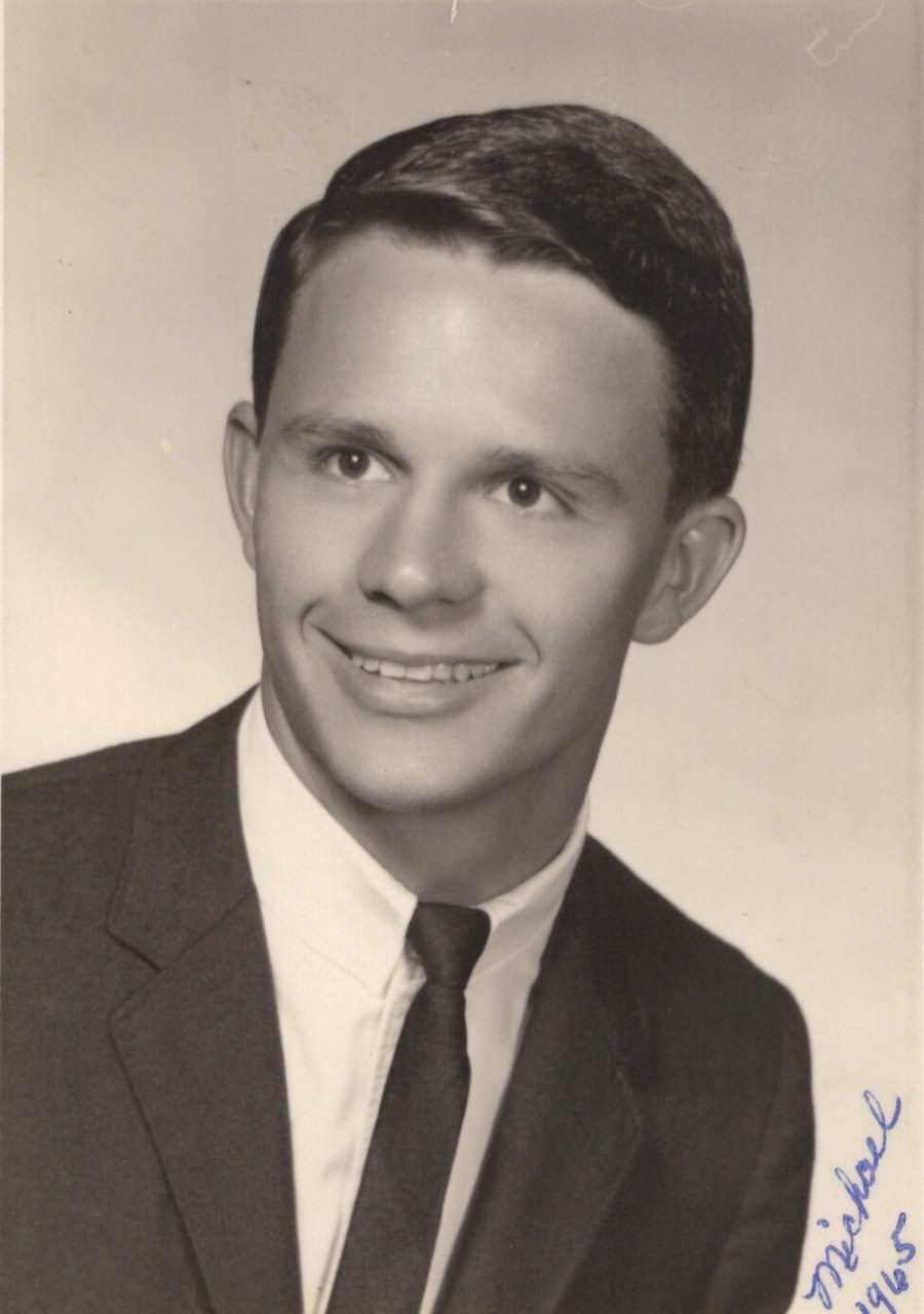 Black and white portrait photograph of a man in formal attire with signature.