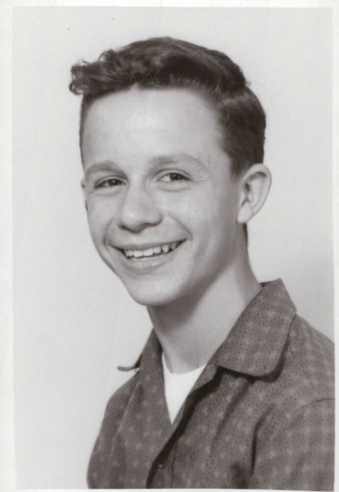 Black and white portrait photograph of a young man smiling at the camera