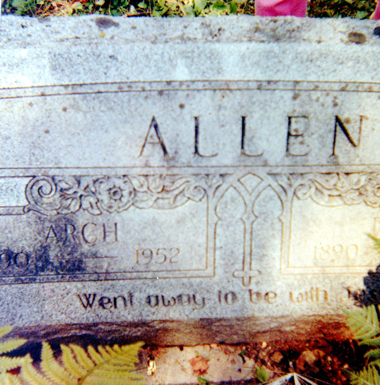 Close-up of weathered stone monument or gravestone with engraved text reading "ALLEN" and decorative Art Deco-style border, dated 1952.